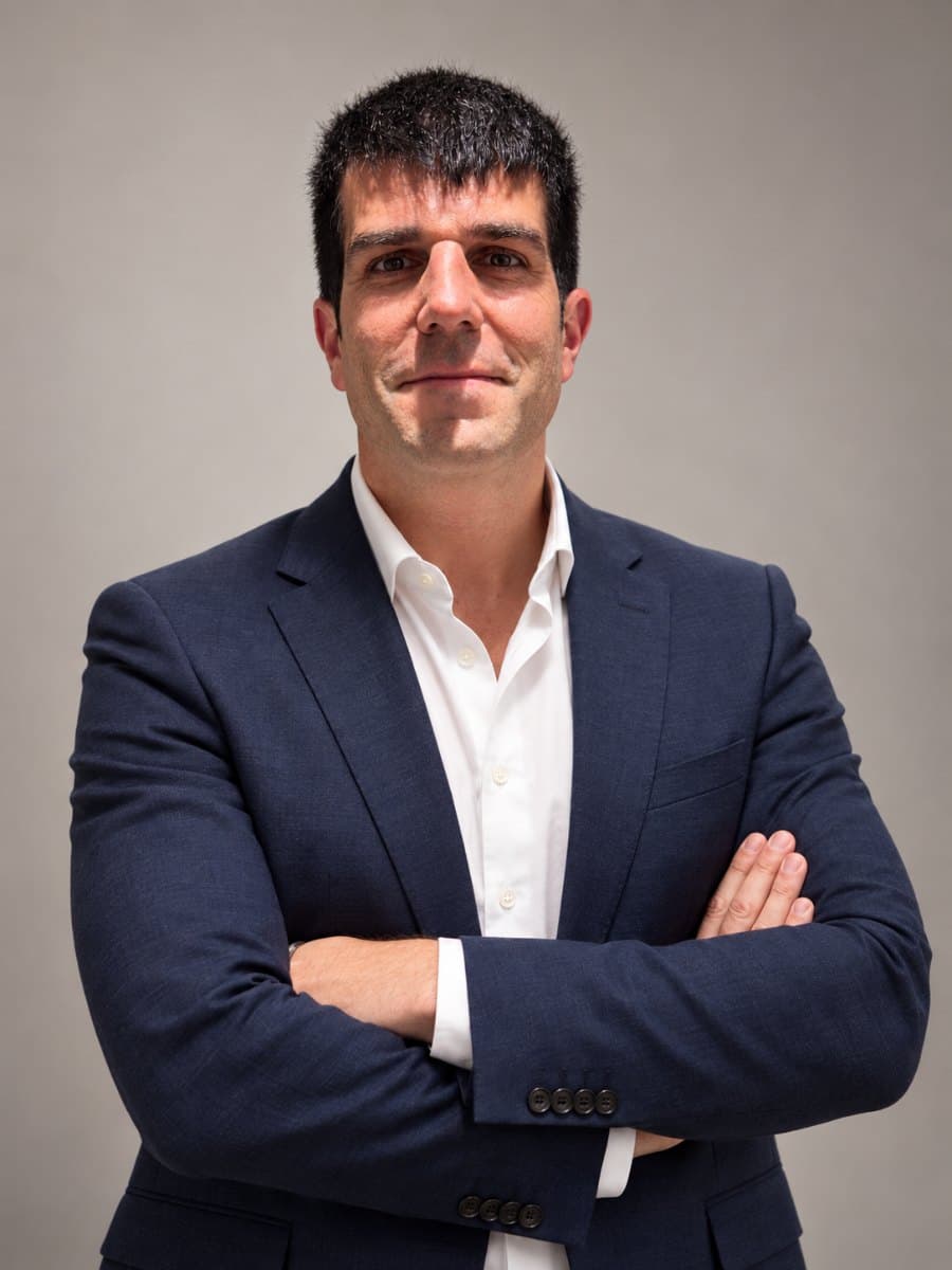 Retrato de Rubén Moral, con americana azul marino y camisa blanca, brazos cruzados
